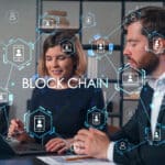 a group of people sitting at a table talking about Blockchain